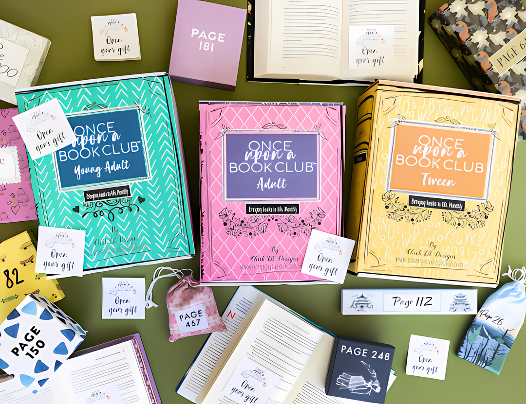 A colorful display of Once Upon a Book Club boxes with themed gifts, books, and "Open Your Gift" stickers.