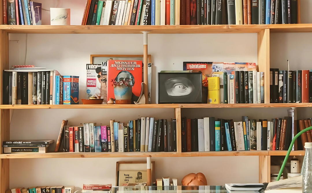 Wooden bookshelves filled with an array of books in a cozy room with soft lighting.