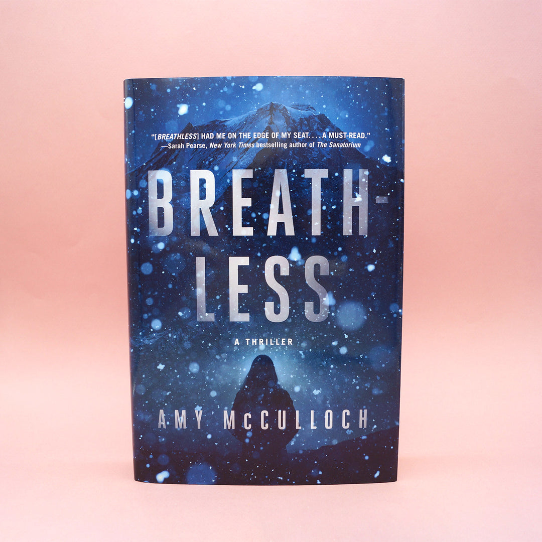 A hardcover copy of Breathless by Amy McCulloch sits on a pink background.