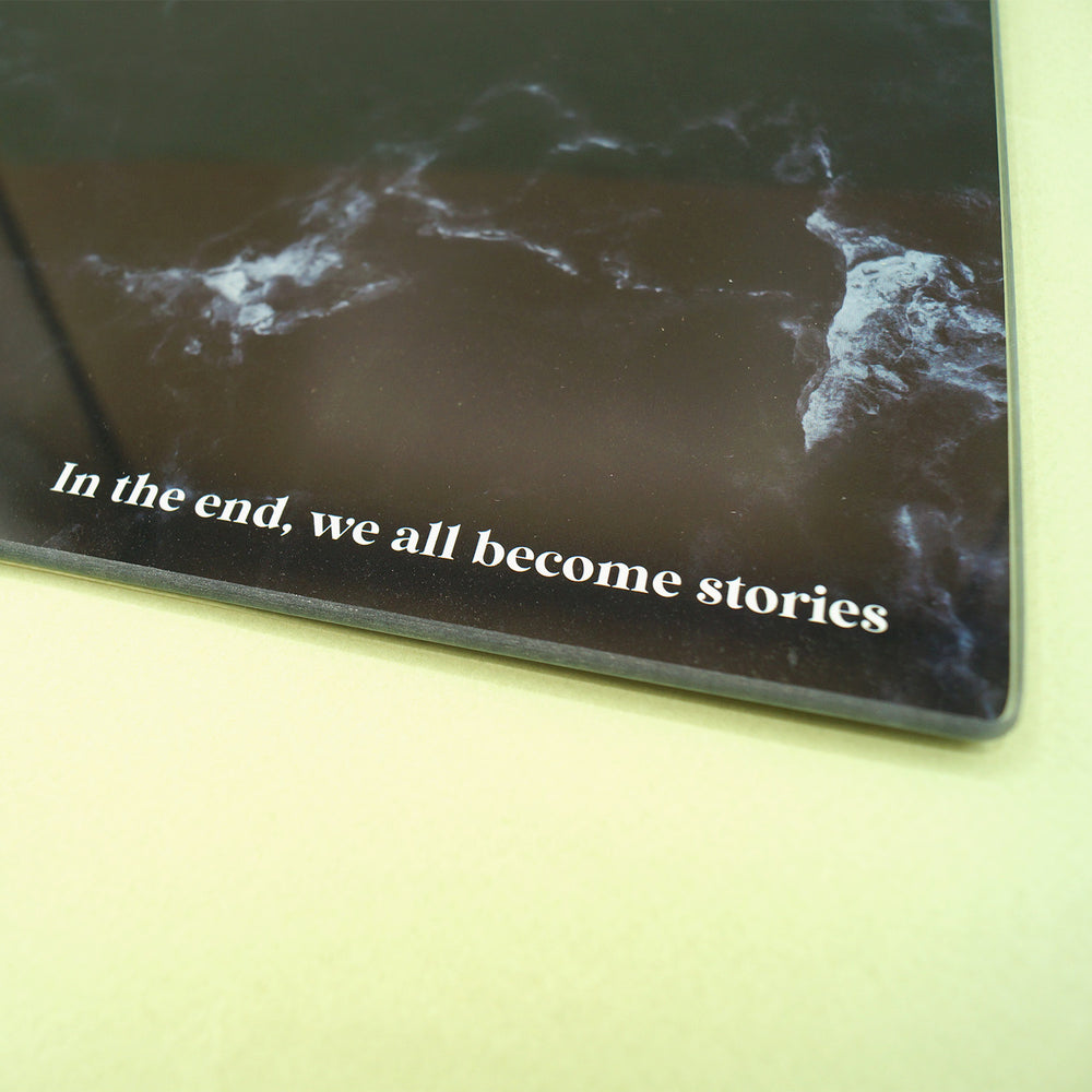 A close up of the quote "In the end, we all become stories" printed at the bottom of the cutting board.