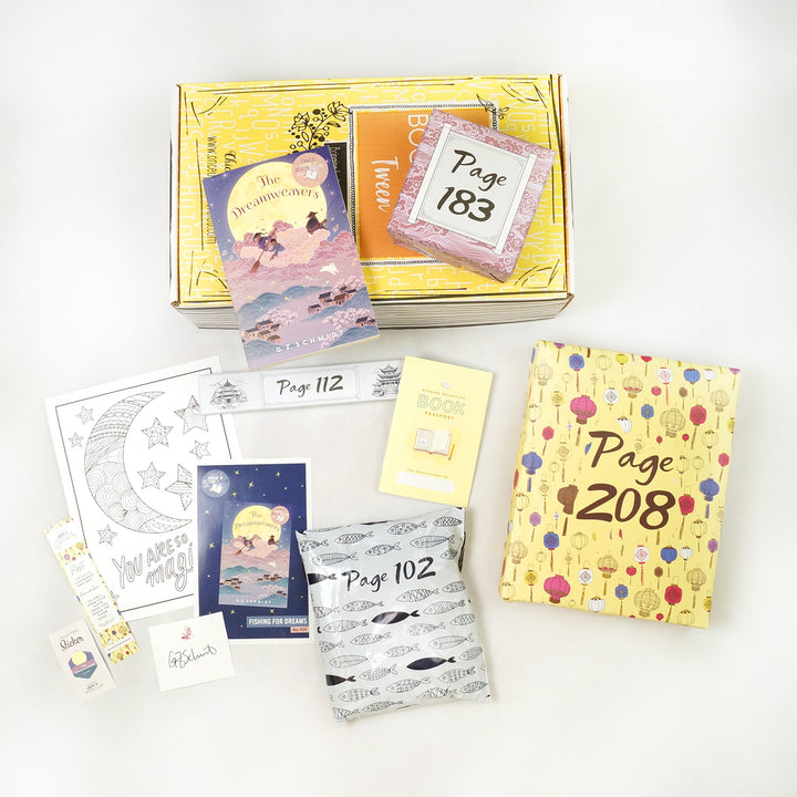 A paperback copy of The Dreamweavers by G.Z. Schmidt sits on a yellow Once Upon a Book Club Tween box. This box is surrounded by wrapped gifts labeled with page numbers in addition to paperwork including a signed bookplate from the author, bookmark, coloring sheet, and matching collectible sticker.