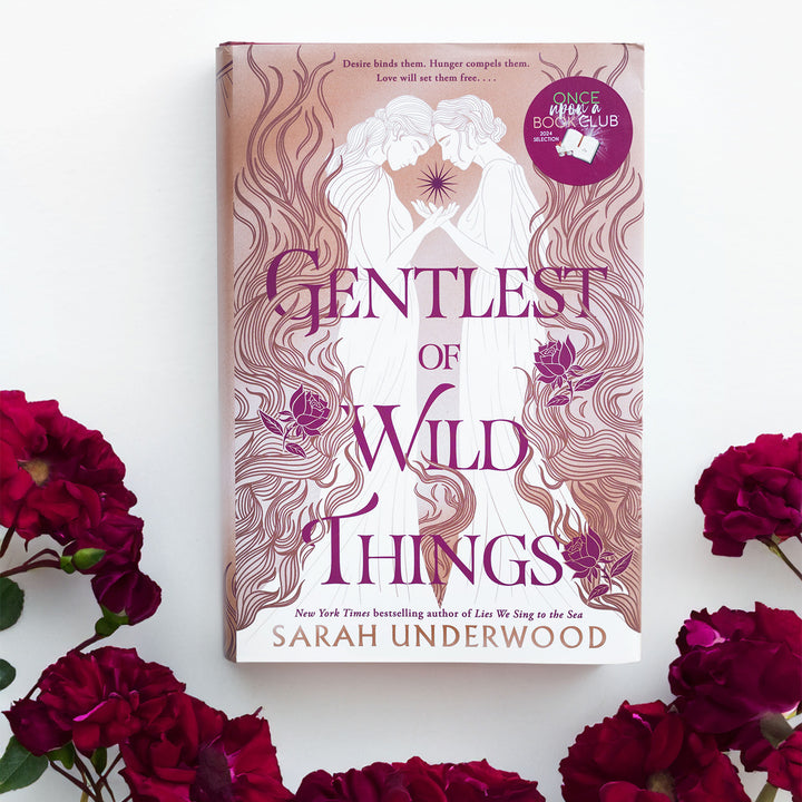 a hardcover copy of Gentlest of Wild Things by Sarah Underwood on a white background surrounded by flowers.