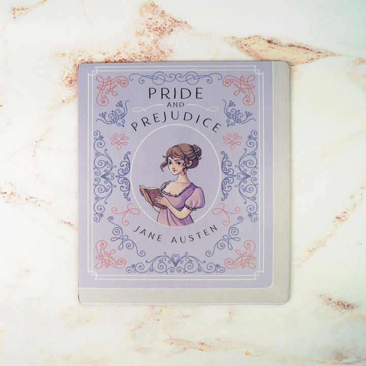 A light purple mouse pad meant to look like the book cover of Pride and Prejudice by Jane Austen featuring an illustration of Elizabeth Bennet in the center.  Sits on a pink marble background.