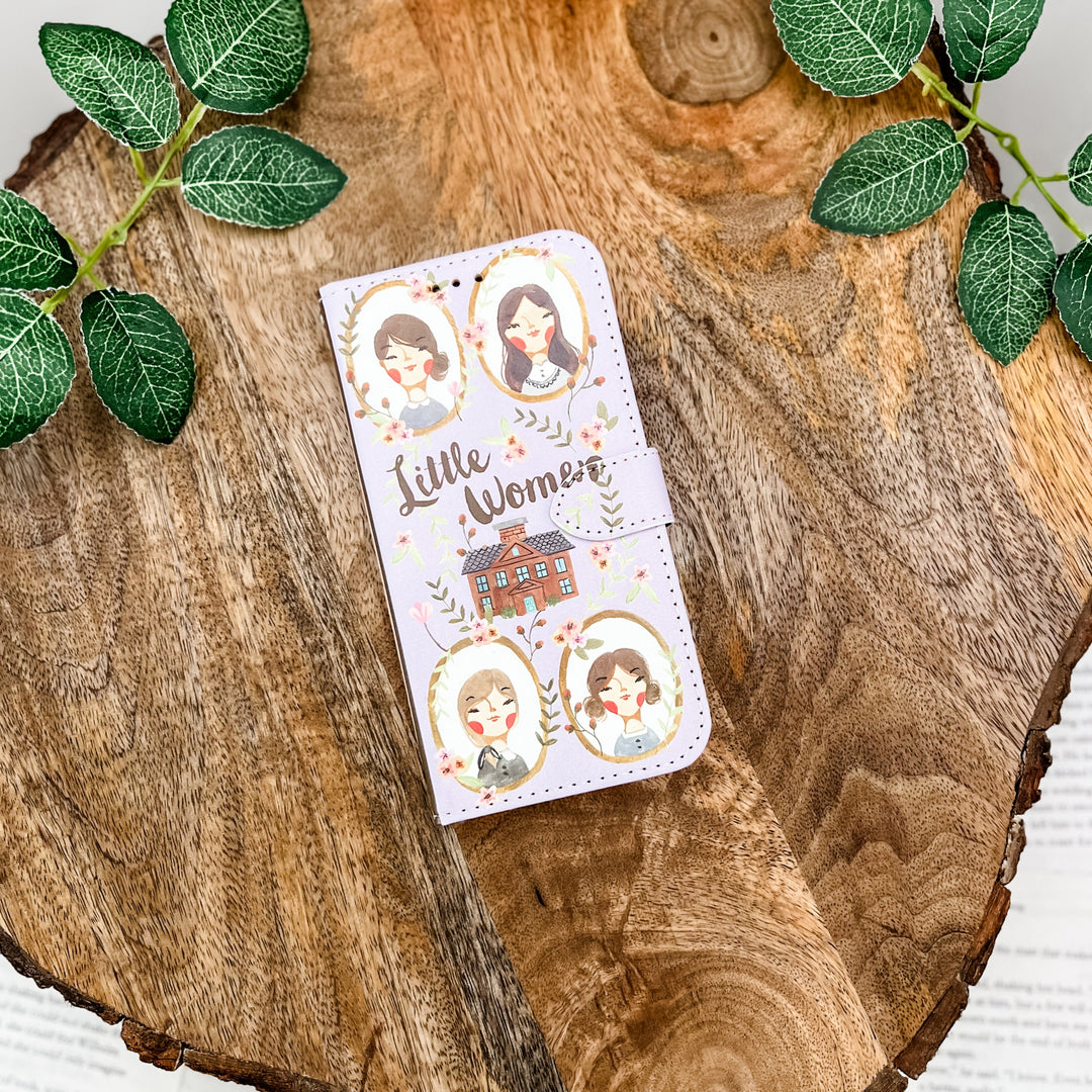 The front of a phone case inspired by Little Women by Louisa May Alcott. The phone case sits on a wood slice surrounded by greenery.