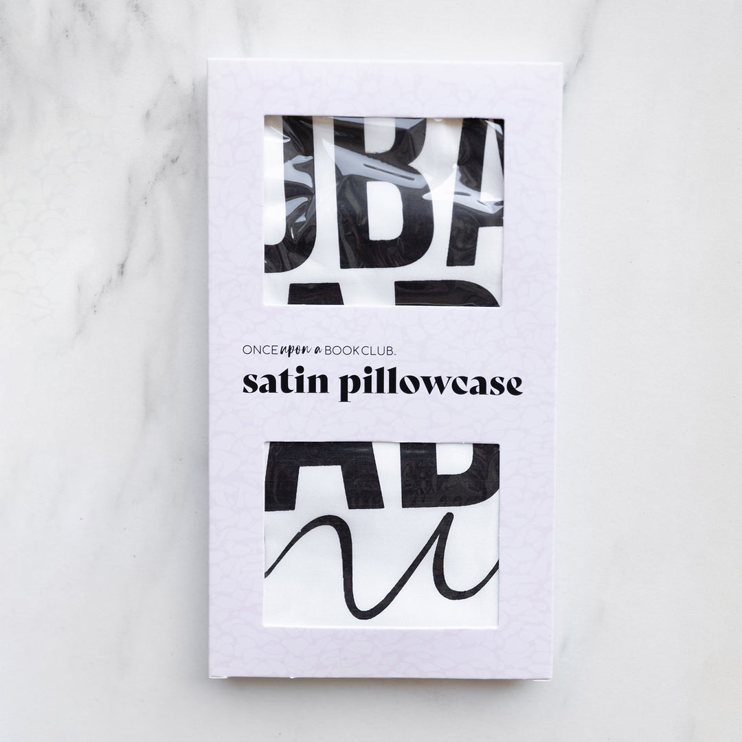 A satin pillowcase in a white window packaging.