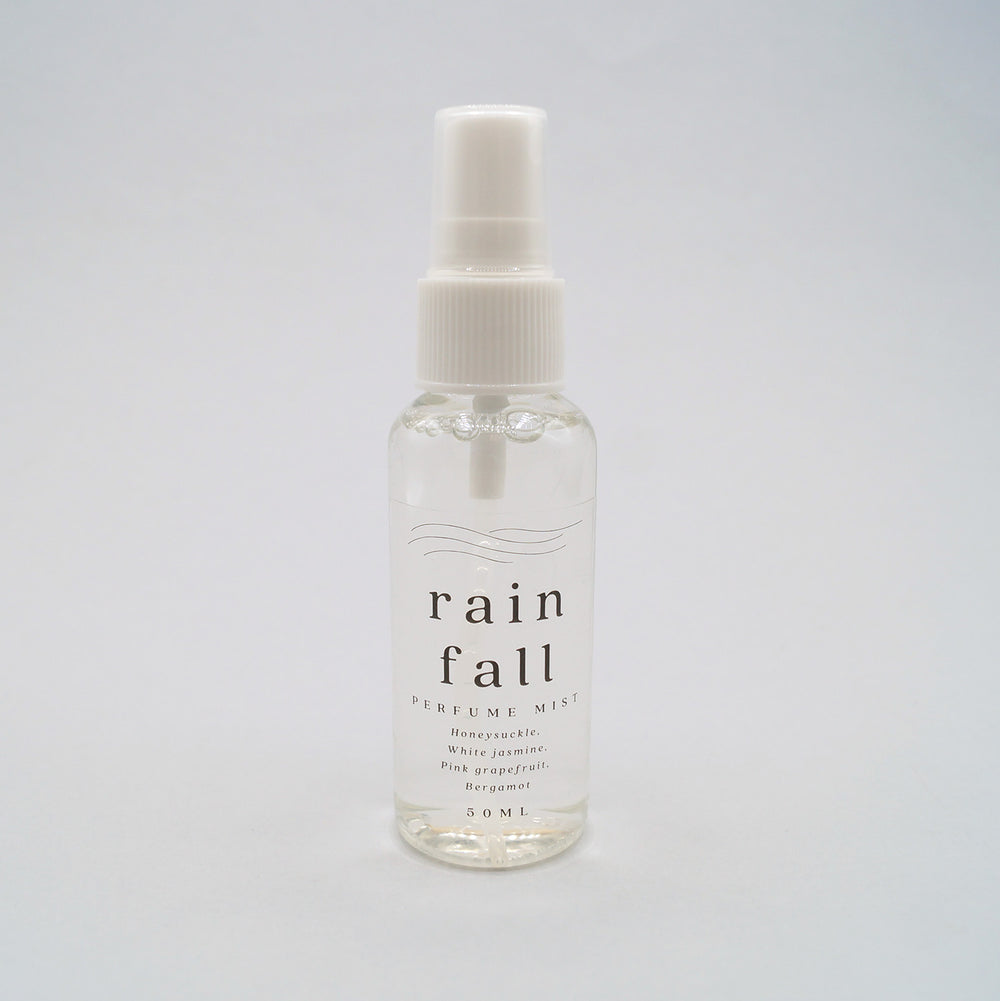 the bottle of rain fall perfume mist with notes of honeysuckle, white jasmine, pink grapefruit, and bergamot.