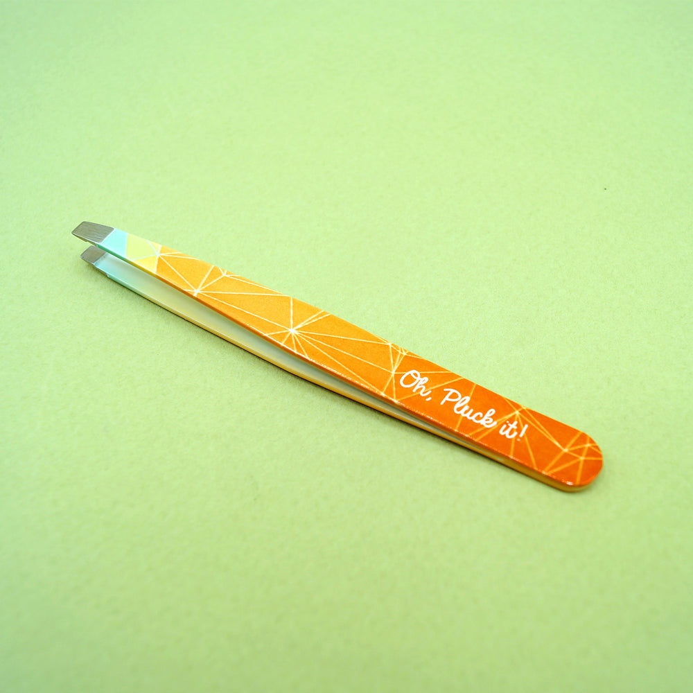 Orange and yellow ombre tweezers that say Oh, Pluck it! on the side.