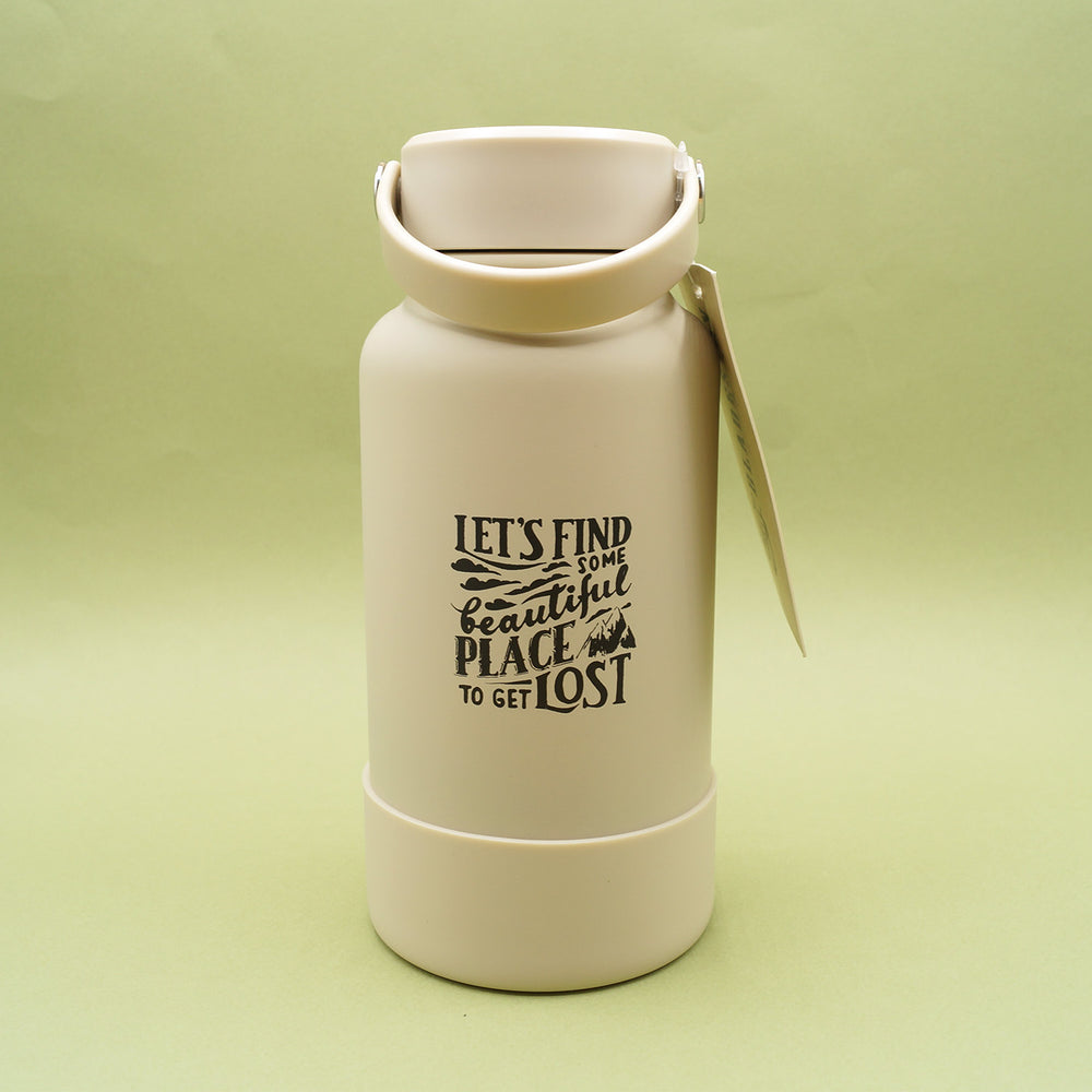 A light taupe colored water bottle with handle lid sits on a green background.